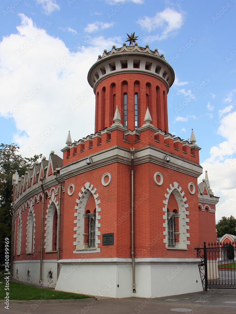 Obraz premium Tower on left side wall of Ancient Petrovsky road Palace Russian landmark near metro Dinamo on Leningradsky Avenue in Moscow, Russia on a summer day on blue sky with clouds backround