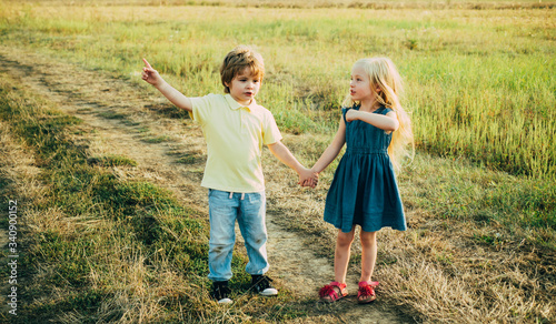 Little couple in love on countryside. Smiling friends laughing. Human emotions and lifestyle concept. Happy kid on summer field. Carefree childhood.
