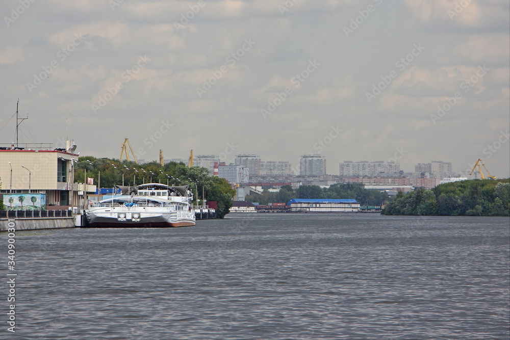 Moscow, Russia, White tourist boat OKA-42 near Pier on Moscow River water on South Port Embankment background on cloudy Summer day