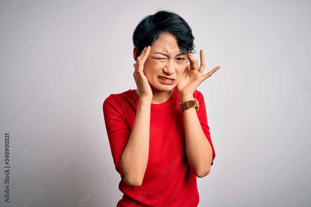 Young beautiful asian girl wearing casual red t-shirt standing over isolated white background with hand on headache because stress. Suffering migraine. Young beautiful asian girl wearing casual red t-shirt standing over isolated white background with hand on headache because stress. Suffering migraine.