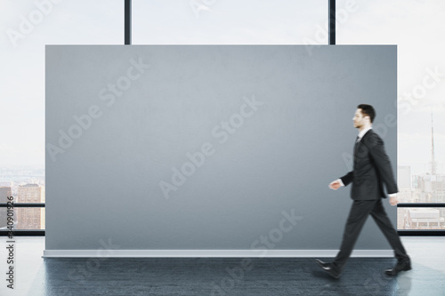 Businessman walking in clean gallery interior