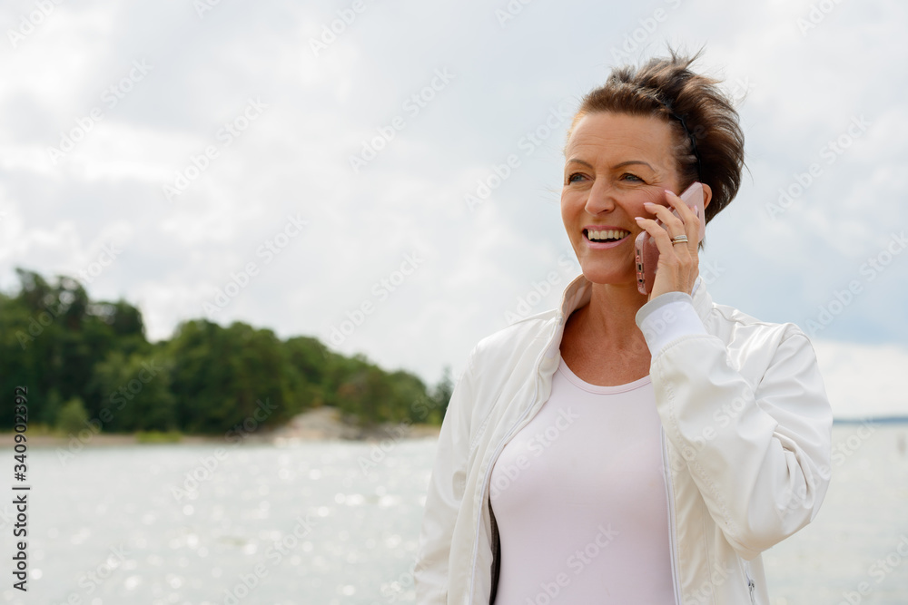 Mature beautiful woman against scenic view of the lake Mature beautiful woman against scenic view of the lake