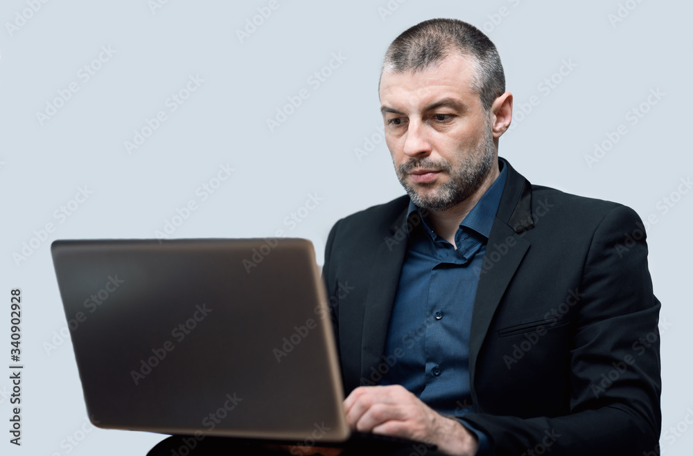 Businessman Working On Laptop Sitting Over Gray Studio Background Businessman Working On Laptop Sitting Over Gray Studio Background