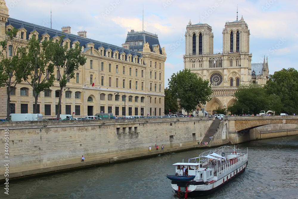 Fototapeta premium Paris, France - August 26, 2018: Tourists enjoy a boat trip on Seine river near Notre Dame cathedral.