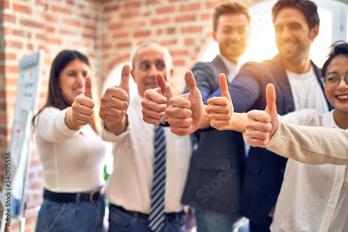 Group of business workers smiling happy. Standing with thumbs up at the office