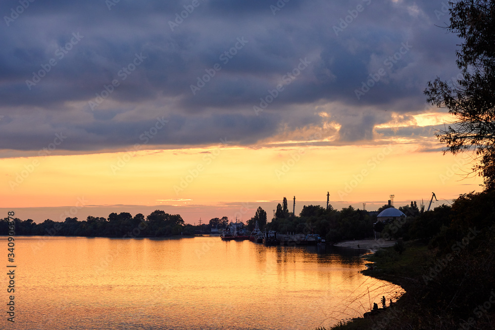 Colorful clouds at sunset over the river in the town