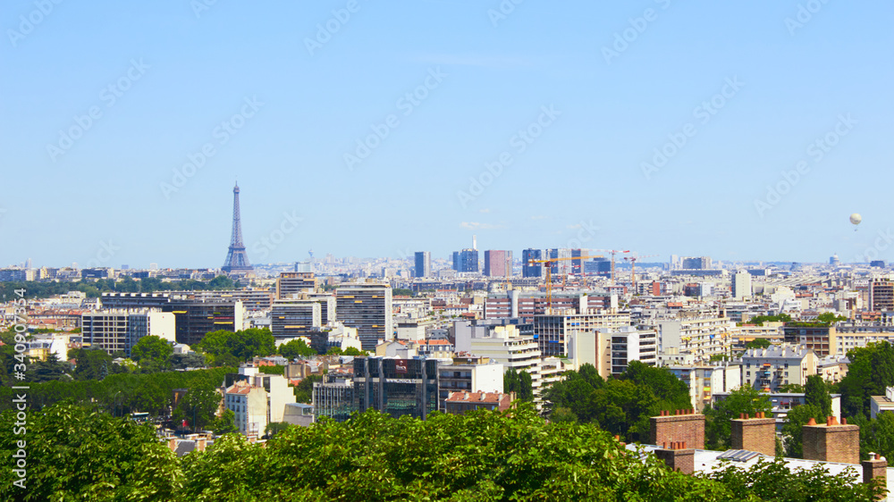 Paris, France - August 26, 2019: Paris from above showcasing the capital city's rooftops, the Eiffel Tower, Paris tree-lined avenues with their haussmannian buildings and Montparnasse tower. 16th