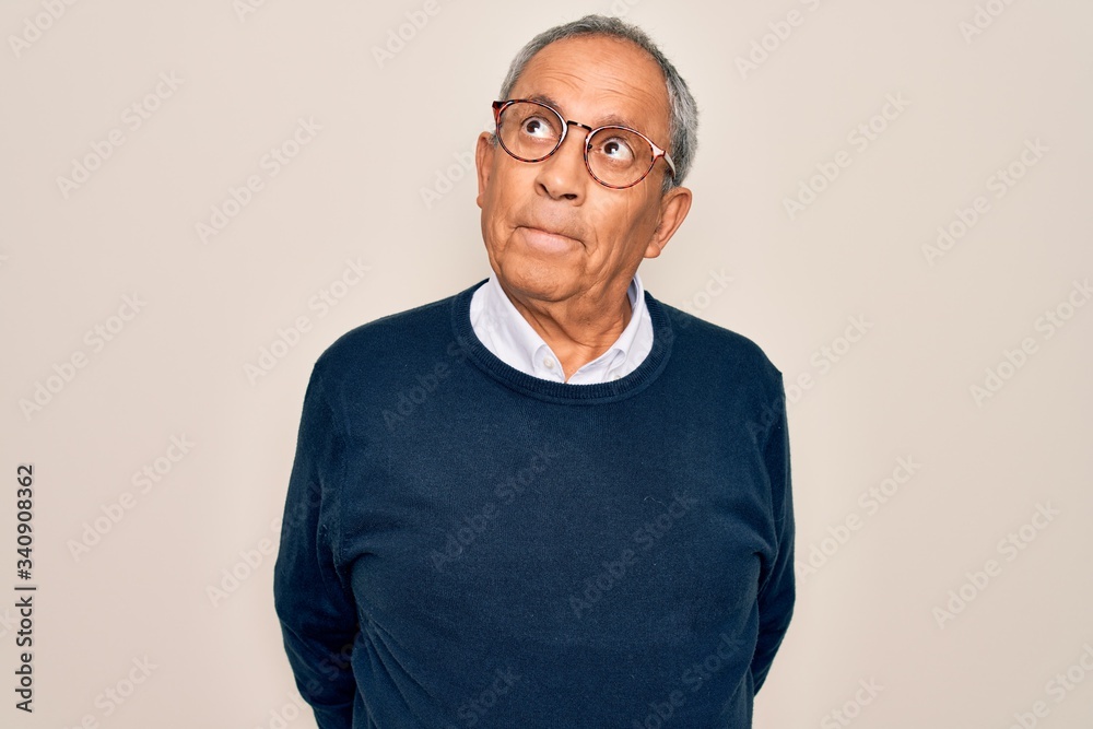 Senior handsome grey-haired man wearing sweater and glasses over isolated white background smiling looking to the side and staring away thinking. Senior handsome grey-haired man wearing sweater and glasses over isolated white background smiling looking to the side and staring away thinking.