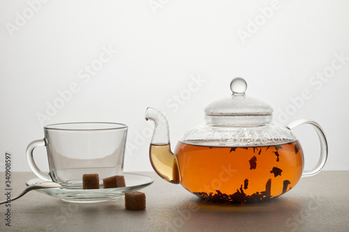 Cup and teapot of green tea with lemon and sugar isolated on white