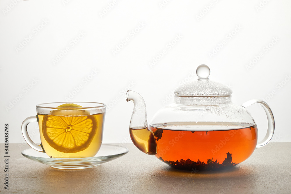 Cup and teapot of green tea with lemon and sugar isolated on white Cup and teapot of green tea with lemon and sugar isolated on white