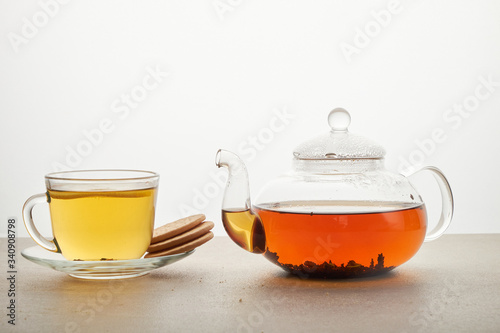 Cup and teapot of green tea with lemon and sugar isolated on white