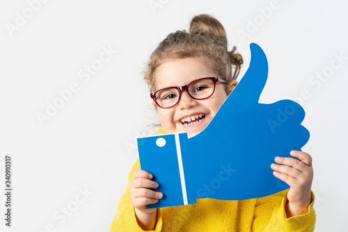 Adorable baby girl is holding a cardboard with the like sign, isolated on white background. photo