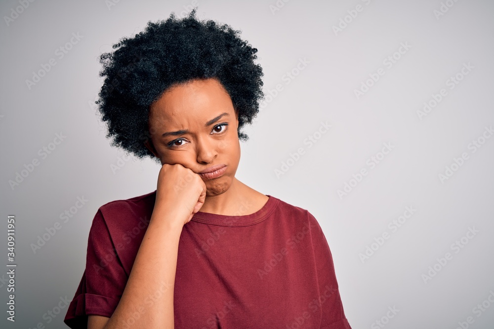 Young beautiful African American afro woman with curly hair wearing casual t-shirt standing thinking looking tired and bored with depression problems with crossed arms. Young beautiful African American afro woman with curly hair wearing casual t-shirt standing thinking looking tired and bored with depression problems with crossed arms.