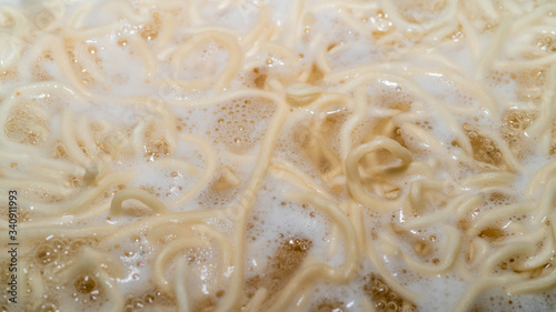 Homemade noodles are boiling in a pot. Close-up macro photo noodles.  While boiling, the smoke of the noodles comes out.