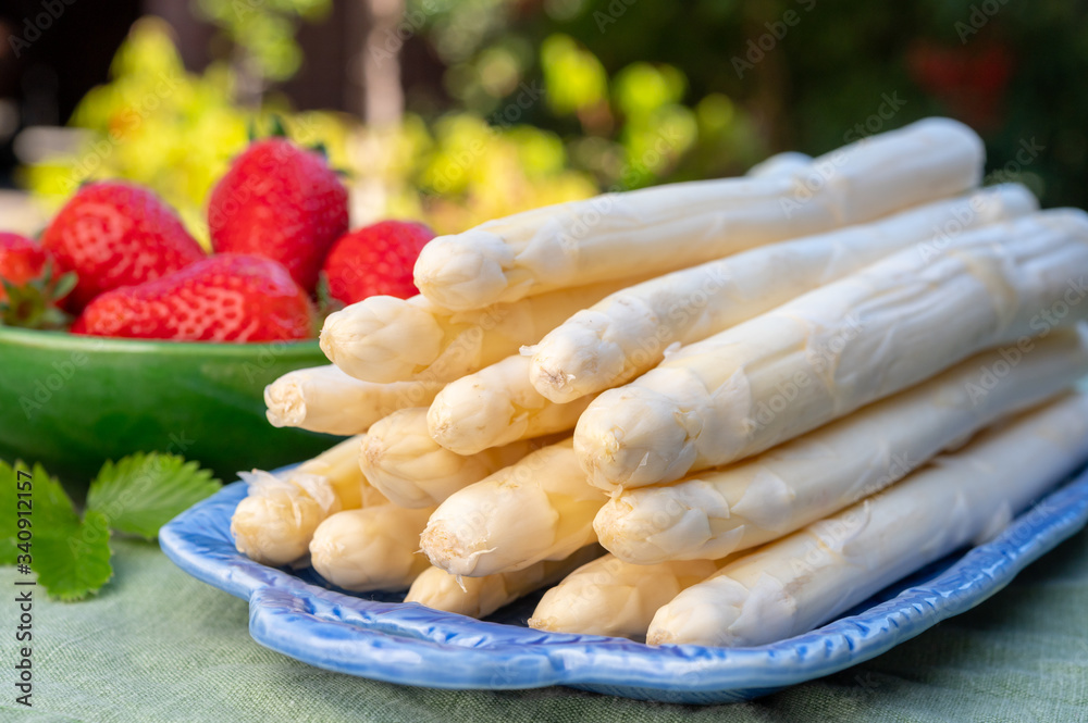 Dutch farmers products, fresh white asparagus and red ripe strawberry in spring sunny garden Dutch farmers products, fresh white asparagus and red ripe strawberry in spring sunny garden