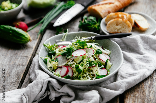 Salad with young cabbage  radish and cucumbers. Vegetarian salad