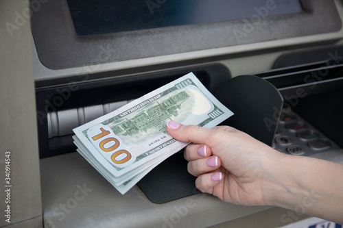 female hand hold money dollars received from an ATM