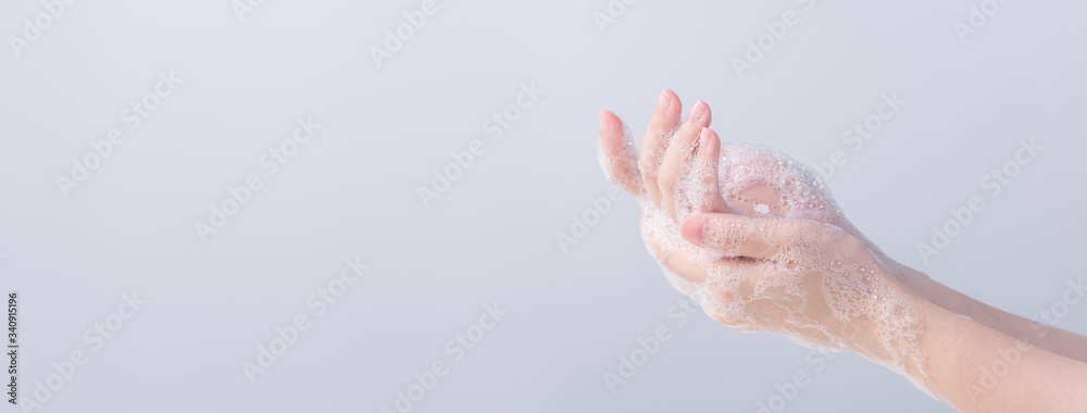 Washing hands. Asian young woman using liquid soap to wash hands, concept of hygiene to protective pandemic coronavirus isolated on gray white background, close up. - obrazy, fototapety, plakaty 