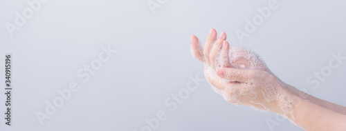 Washing hands. Asian young woman using liquid soap to wash hands, concept of hygiene to protective pandemic coronavirus isolated on gray white background, close up.