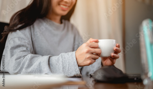 Woman holding a coffee cup work from home wait epidemic situation to improve soon at home. Coronavirus, covid-19, Work from home (WFH), Social distancing, Quarantine, Prevent infection concept.