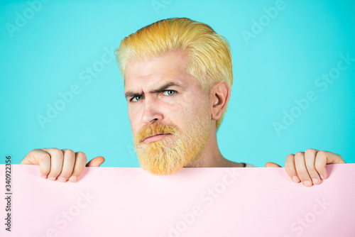 Man holding card, man with banner, isolated blue background, man showing empty card. photo