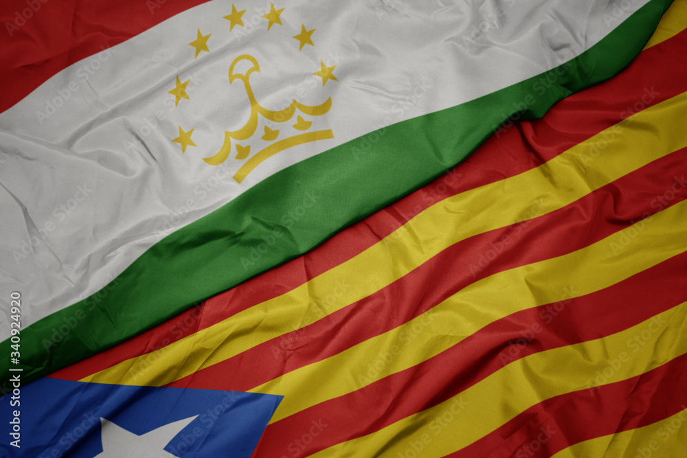 waving colorful flag of catalonia and national flag of tajikistan. waving colorful flag of catalonia and national flag of tajikistan.
