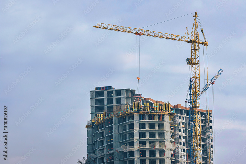 construction of a new high-rise multi-storey building for a large number of apartments. two tower cranes are working at the construction site construction of a new high-rise multi-storey building for a large number of apartments. two tower cranes are working at the construction site