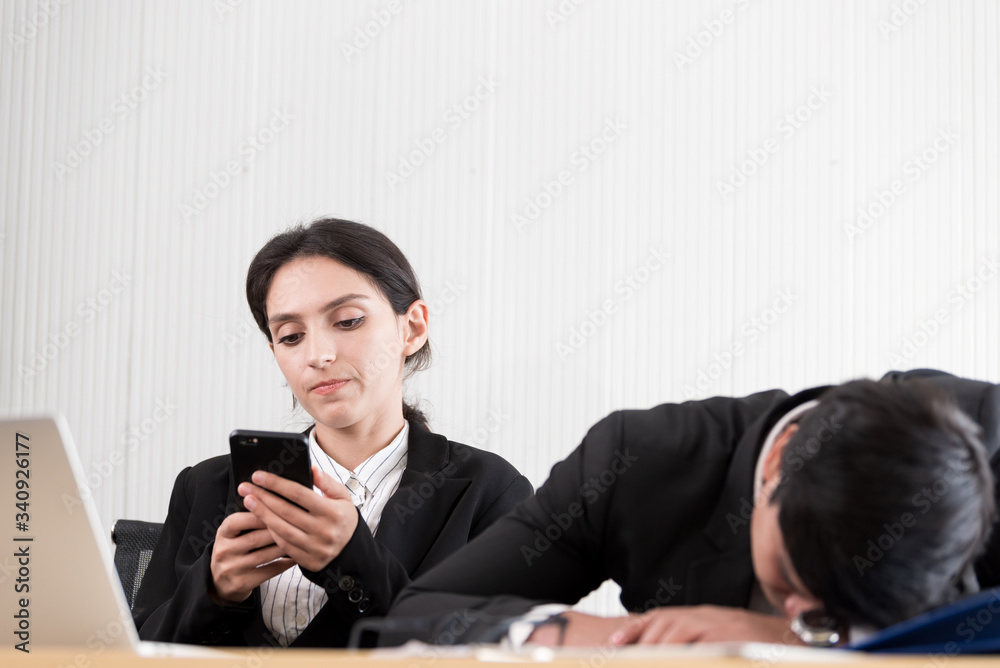 Two employees have lazy and playing the phone and sleep at the office in a relaxing time. Two employees have lazy and playing the phone and sleep at the office in a relaxing time.