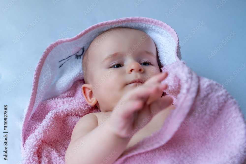 Six month baby girl wearing towel after bath. Childhood and baby care concept Six month baby girl wearing towel after bath. Childhood and baby care concept