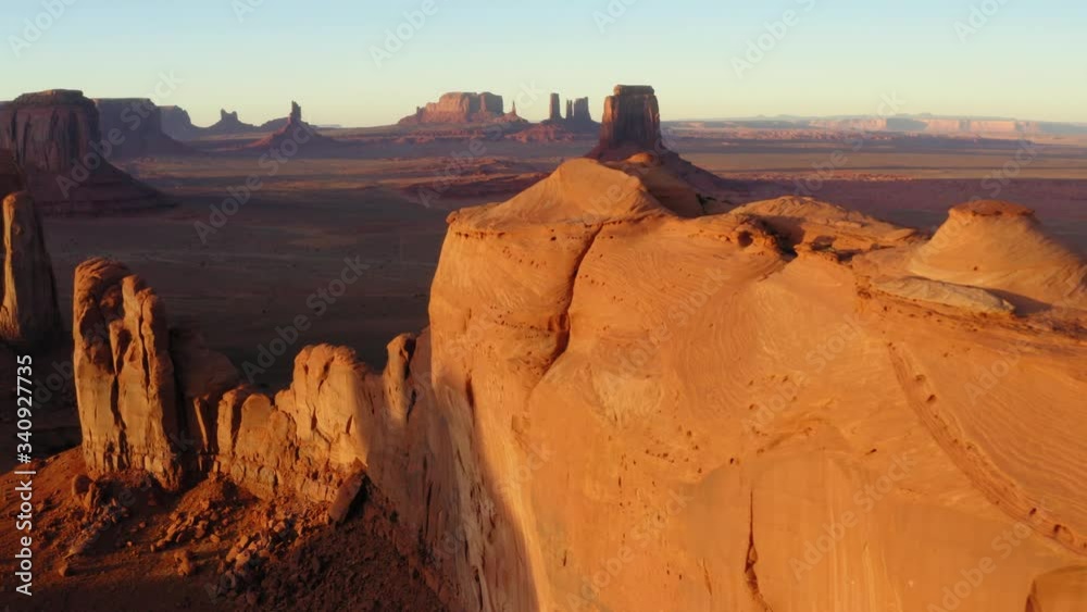 Beautiful Panoramic Aerial View of Monument Valley At Sunset, Elevating Reveal of Expansive Western Landscape from behind Canyon Walls