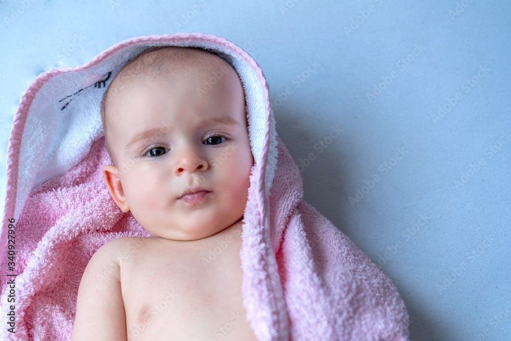 Six month baby girl wearing towel after bath. Childhood and baby care concept Six month baby girl wearing towel after bath. Childhood and baby care concept