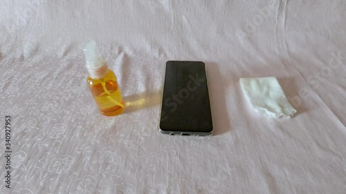 A man disinfects a smartphone with antibacterial wipes and a sanitizer during the Covid -19 epidemic