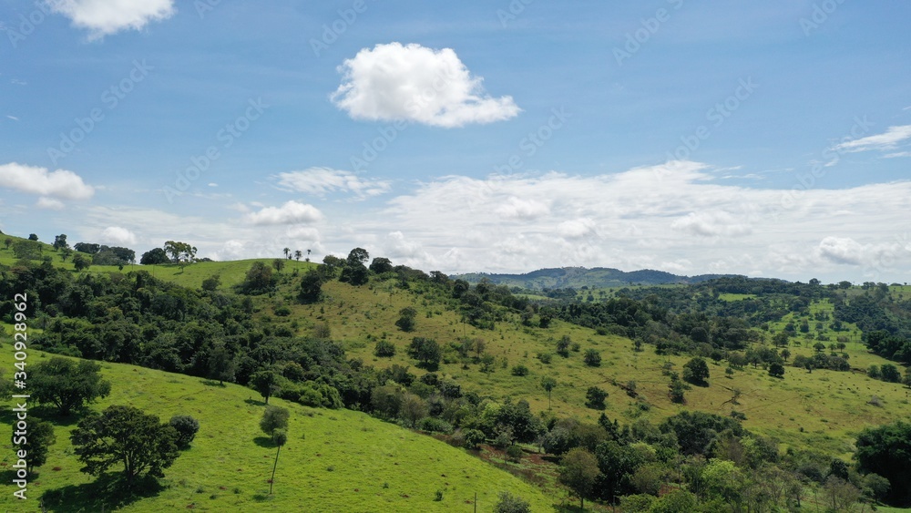 Brazilian farm with pastureland among mountains and native Cerrado vegetation. Ceres, Goias State, Brazil 