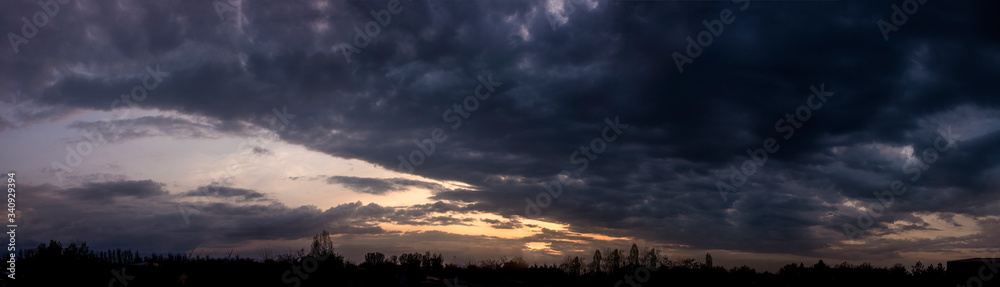 The sky, the sun setting behind the clouds.