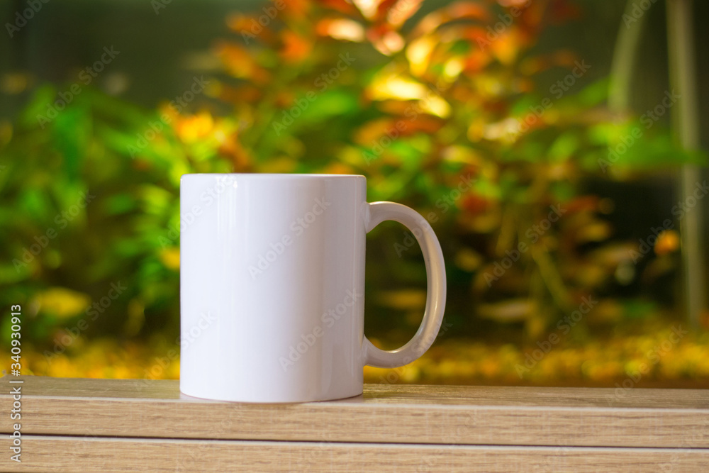 white cup for sublimation printing outdoor on the colored background of flowers and leaves in aquarium white cup for sublimation printing outdoor on the colored background of flowers and leaves in aquarium
