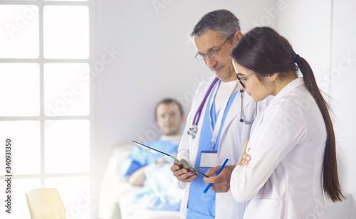 Doctor checking heart beat of patient in bed with stethoscope