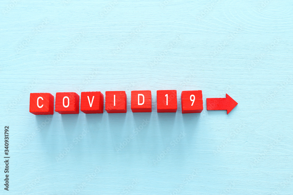 concept image of coronavirus idea. red wooden cubes with the text covid 19 over blue background concept image of coronavirus idea. red wooden cubes with the text covid 19 over blue background