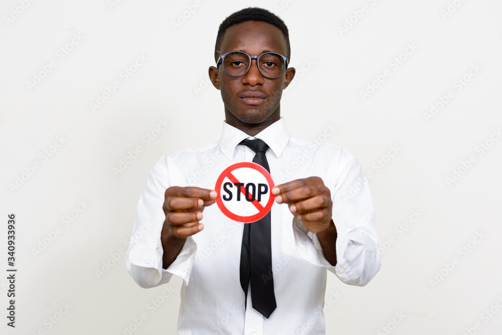 Portrait of young African businessman holding stop sign Portrait of young African businessman holding stop sign
