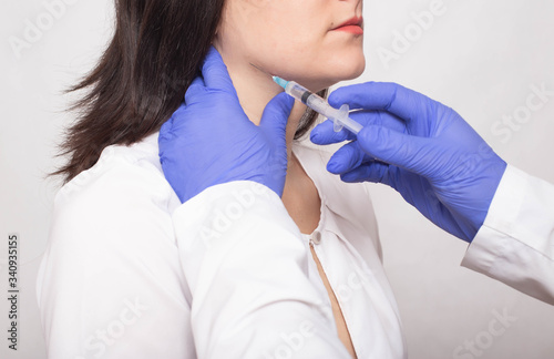 Taking a biopsy from a girl from the salivary gland to check for a benign or malignant tumor, cancer photo