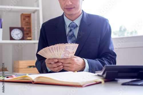 Obraz na plátně Business people sit and count money thai baht on the desk in the office, profita