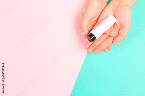 female  manicure. Beautiful young woman's hands with bottles of cosmetics  on pastel background .
