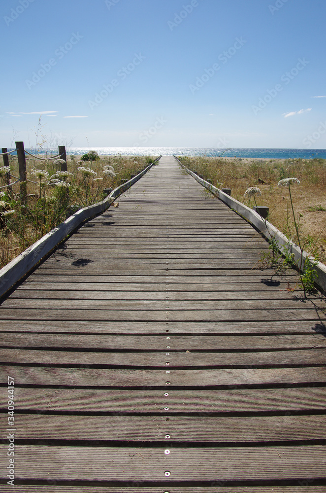 A wooden walkway leading to the sea