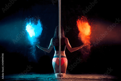 girl next to the pole throws flour on a black background