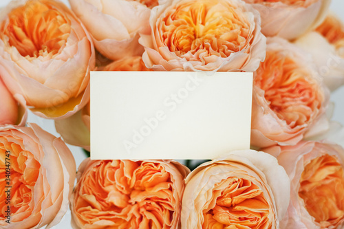 Wedding invitation on a bunch of orangeroses photo