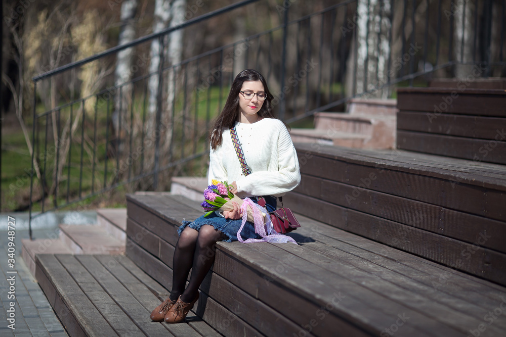beautiful girl walks with a bouquet of spring flowers along the promenade beautiful girl walks with a bouquet of spring flowers along the promenade