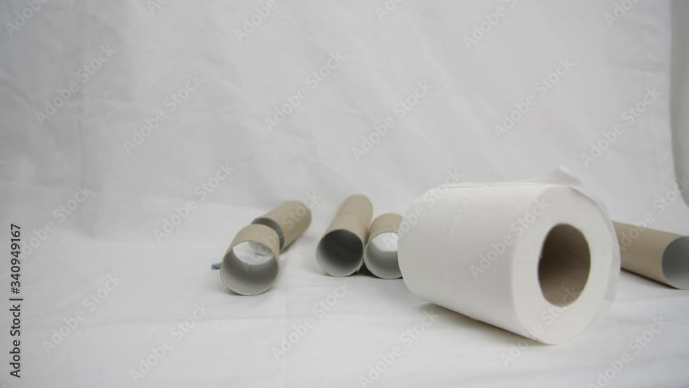 Cardboard toilet roll tubes in a triangle formation get knocked down by