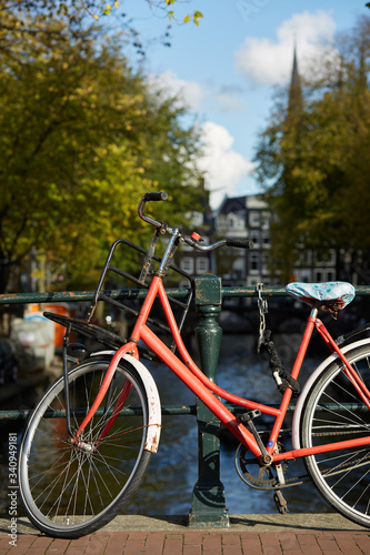 A bicycle parked on a bridge over an Amsterdam canal