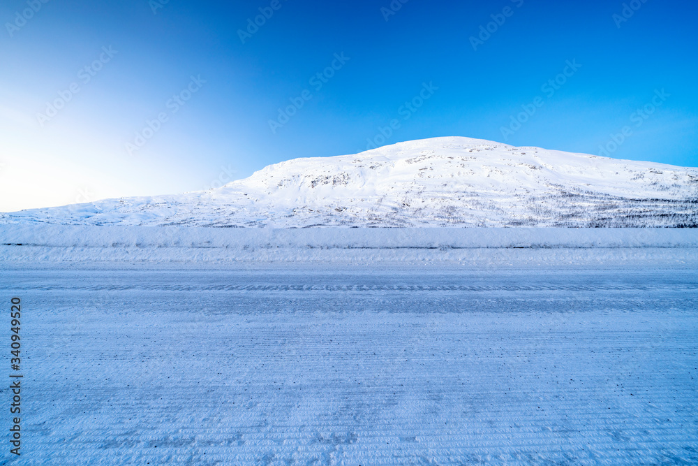  Icy road against snowcapped mountain