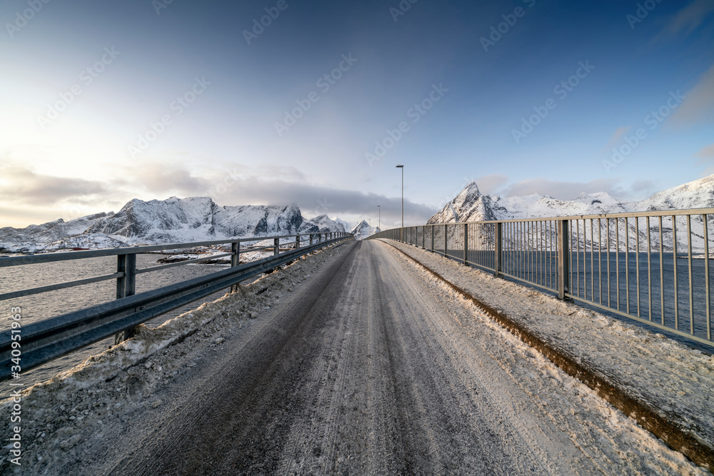 Bridge against snowcapped mountains in Reine, Norway Bridge against snowcapped mountains in Reine, Norway