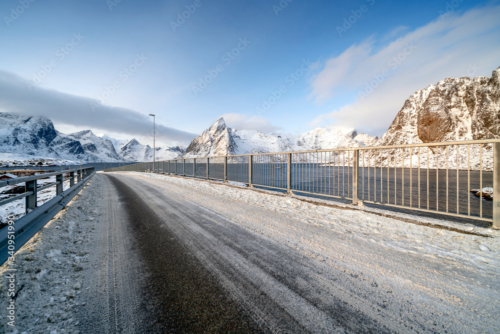 Bridge against snowcapped mountains in Reine, Norway Bridge against snowcapped mountains in Reine, Norway